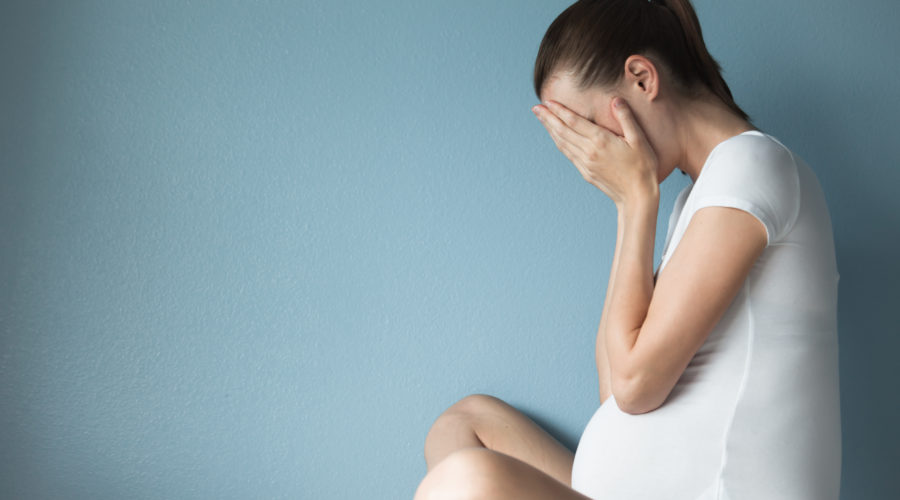 upset pregnant woman crying in her hands